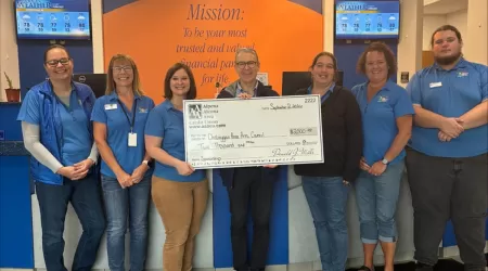 Community Foundation of Northeast Michigan Youth Advisory Council Members pose with a $505.00 check and posters advertising YAC Day